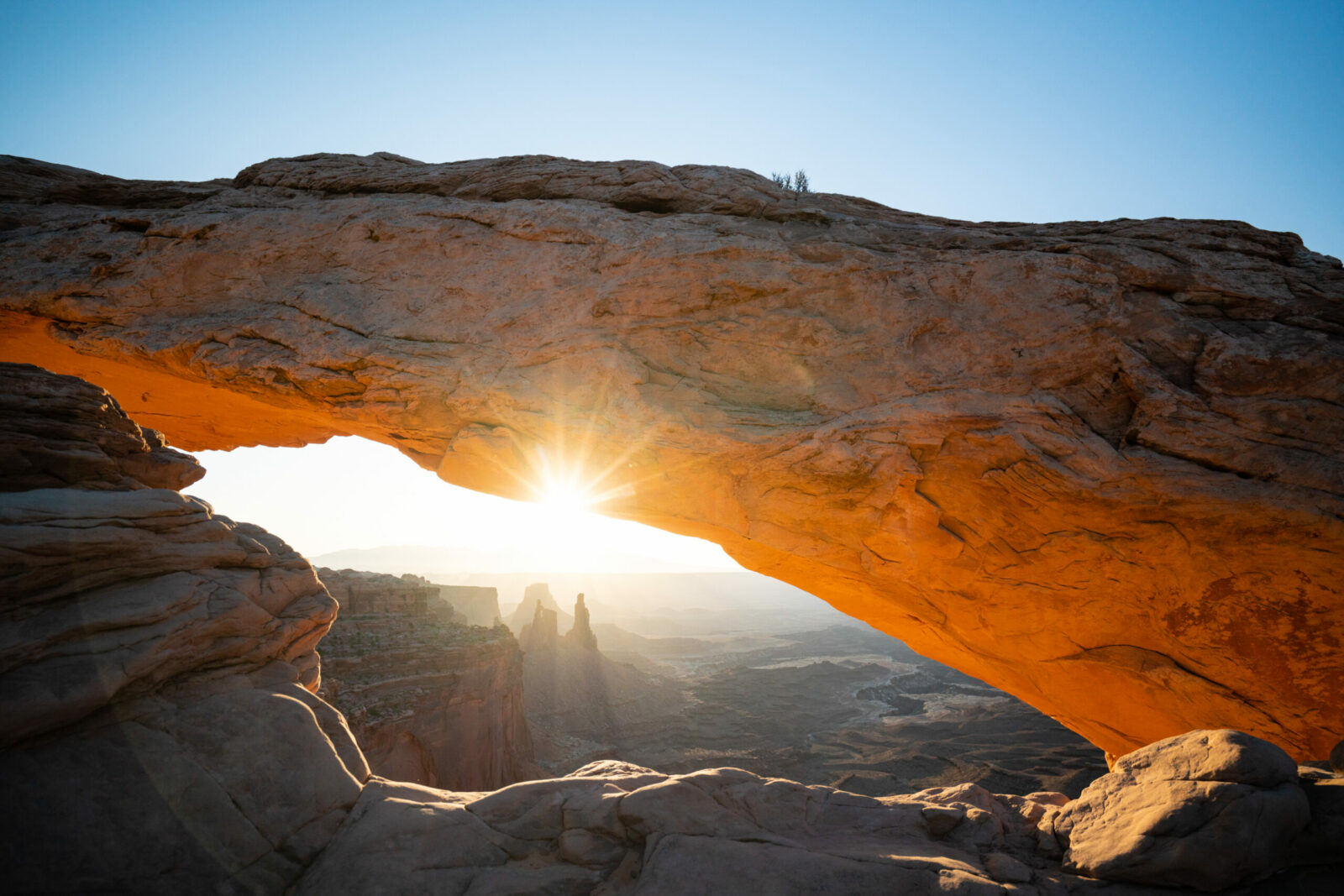 Sun rising over an arch in Canyonlands National Park
